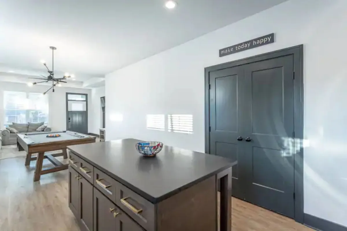 This interior image highlights a lively, open space featuring a pool table and a kitchen island, surrounded by cheerful decor and bright lighting. The area is ideal for group gatherings, socializing, and unwinding after an evening out in the city, seamlessly tying back to the section's mention of games and communal relaxation.